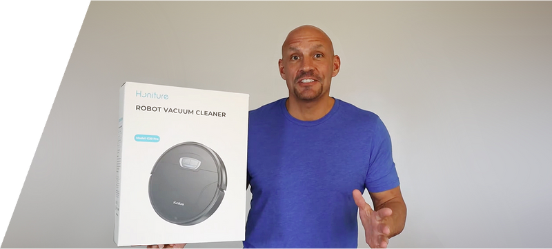 Hombre mostrando un robot aspirador negro Honiture en un vídeo o reseña de análisis de producto.