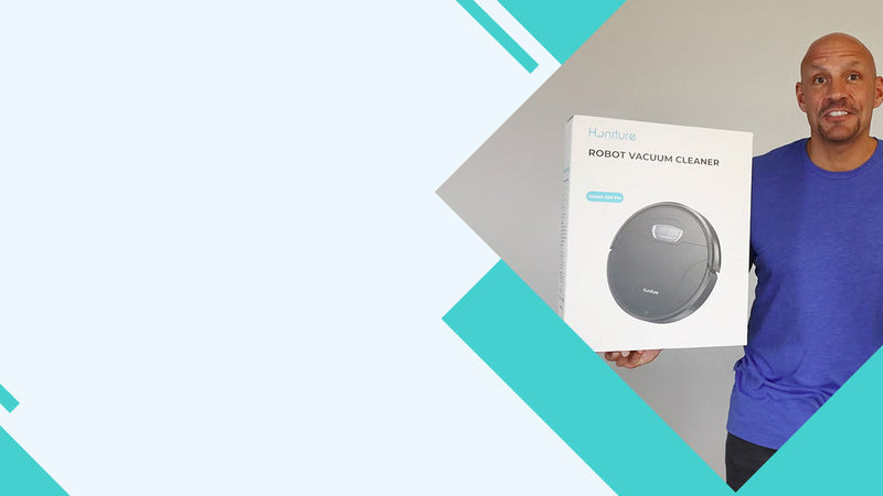 Hombre mostrando un robot aspirador negro Honiture en un vídeo o reseña de análisis de producto.